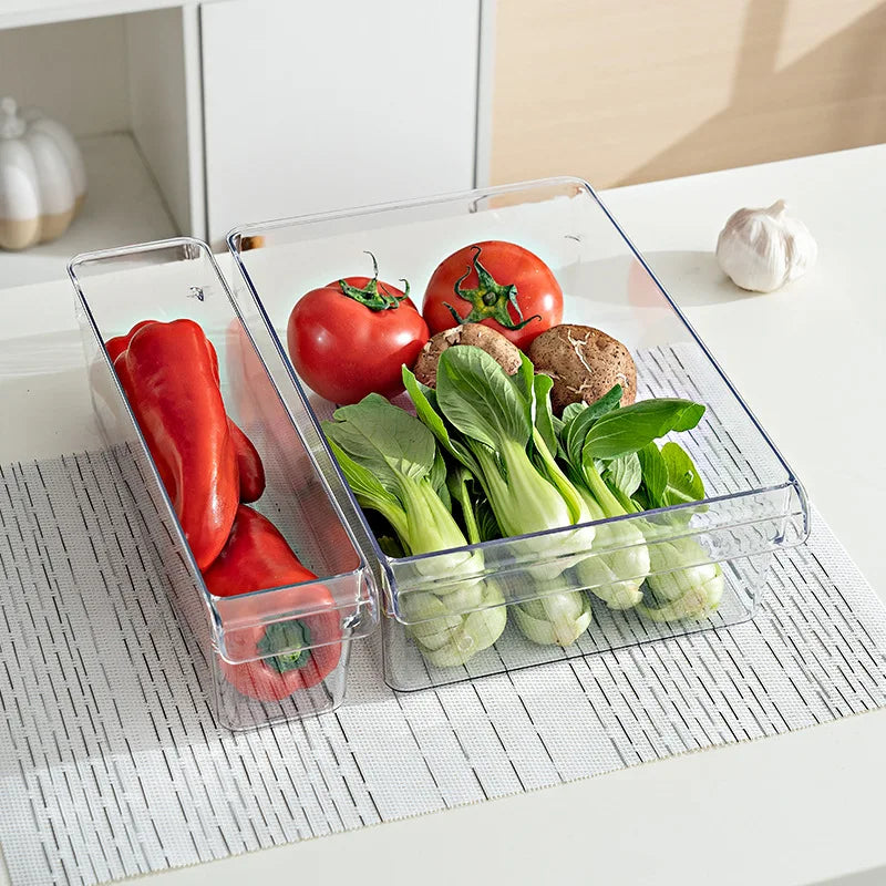 Clear refrigerator storage containers holding fresh vegetables like tomatoes and bell peppers for organized food storage.