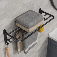 Matte black folding aluminium towel rack with hooks, showcasing neatly arranged towels for modern bathroom organization.