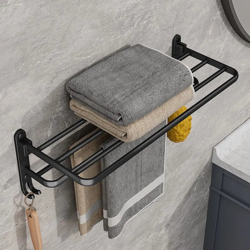 Matte black folding aluminium towel rack with hooks, showcasing neatly arranged towels for modern bathroom organization.