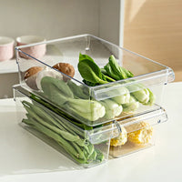 Eco-friendly clear refrigerator storage containers stacked with fresh vegetables for organized fridge.