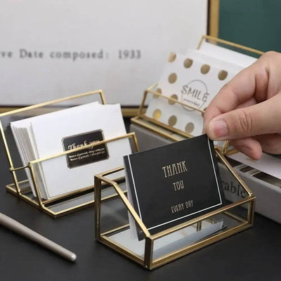 Elegant glass business card holder with gold trim, showcasing thank you cards and stylish organization.