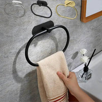 Self-adhesive stainless steel towel holder in black, showcasing its modern design with a towel hanging.