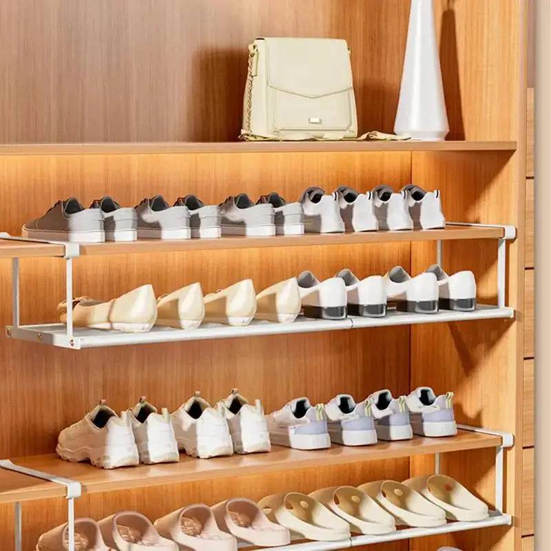 Retractable shoe rack displaying neatly organized footwear and a stylish handbag on wooden shelves.