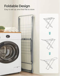 Foldable clothes drying rack displayed next to a washing machine, showcasing easy setup and space-saving design.