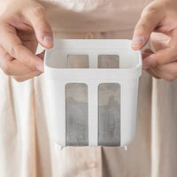 Hands holding a stainless steel yogurt strainer whey separator tool for making thick yogurt and cheese.