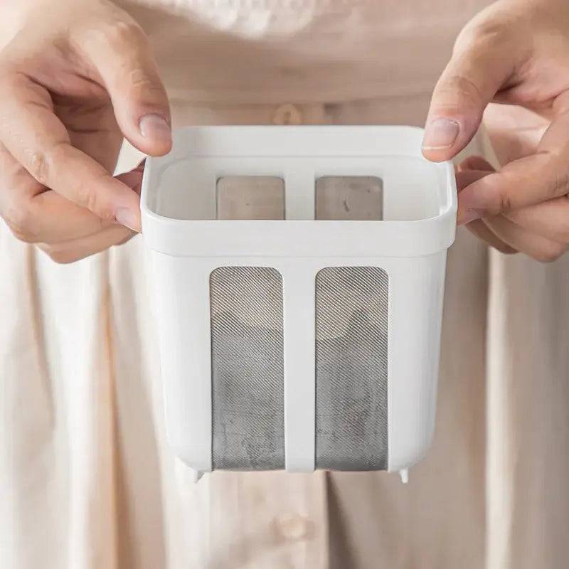 Hands holding a stainless steel yogurt strainer whey separator tool for making thick yogurt and cheese.