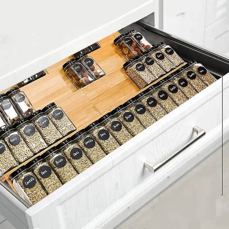 Organized bamboo spice rack in a drawer showing labeled spice jars for efficient kitchen storage.