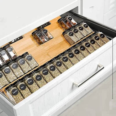 Organized bamboo spice rack in a drawer showing labeled spice jars for efficient kitchen storage.