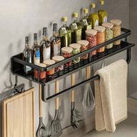 Wall-mounted spice rack with towel bar, featuring jars of spices and cooking oils, enhancing kitchen organization.