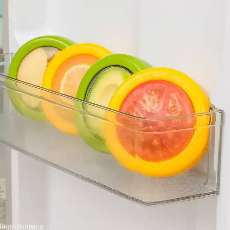 Colorful silicone food storage container lids keeping sliced fruits fresh in a fridge organizer.