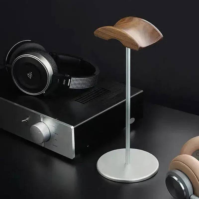 Stylish walnut headphone stand with aluminium base on a modern desk, showcasing elegance and functionality.