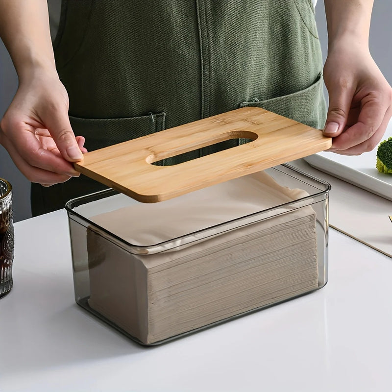 Person placing a bamboo lid on a modern glass tissue box, showcasing an elegant tissue storage solution.